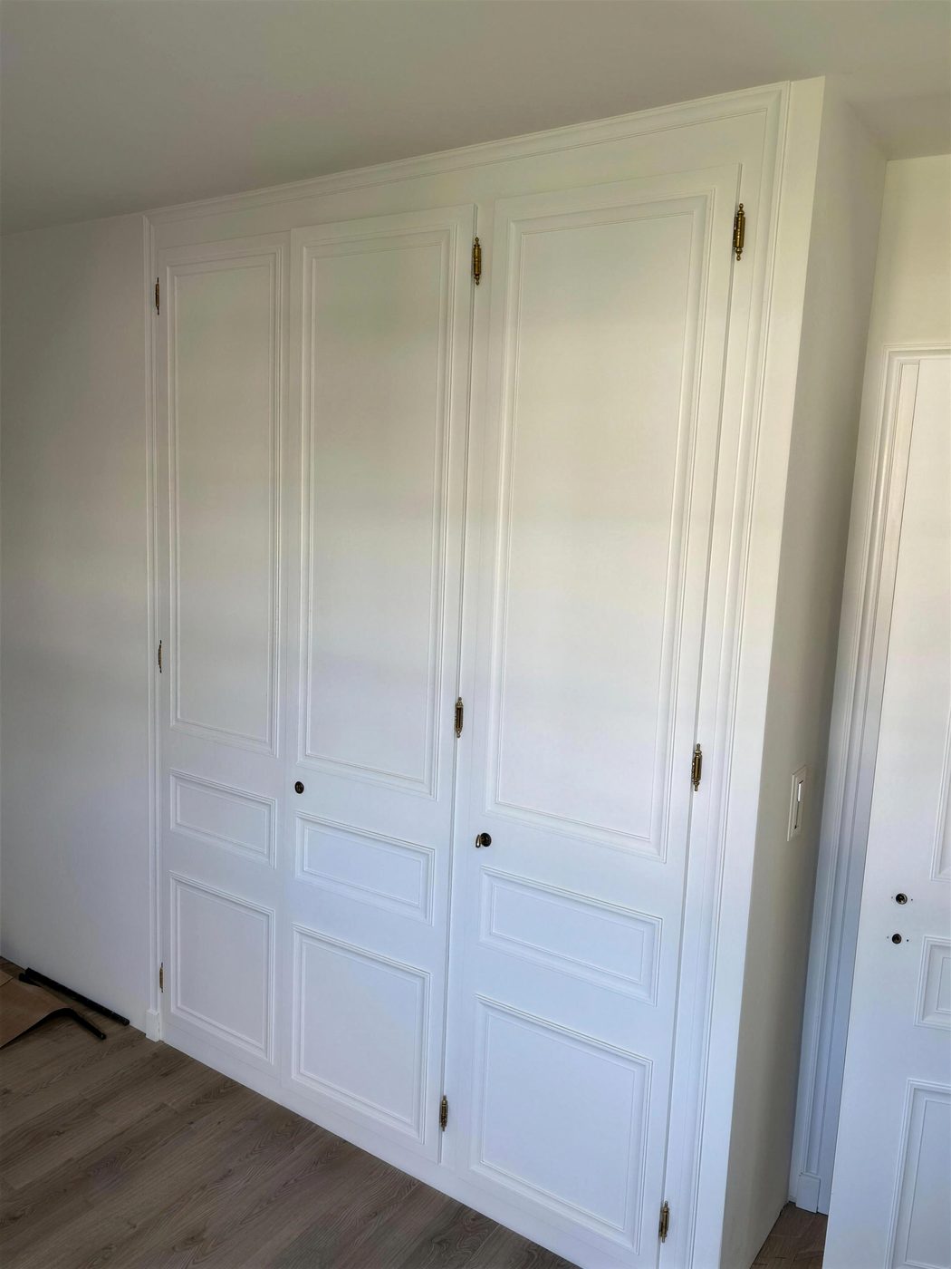 Armoire à panneaux repeinte en blanc