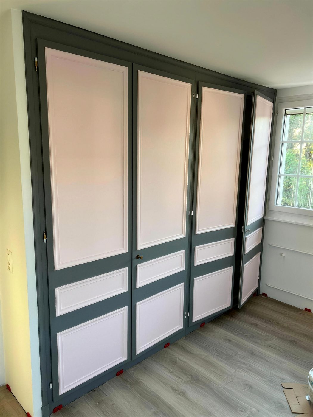 La même armoire en deux tons : cadres anthracite, panneaux rose pâle
