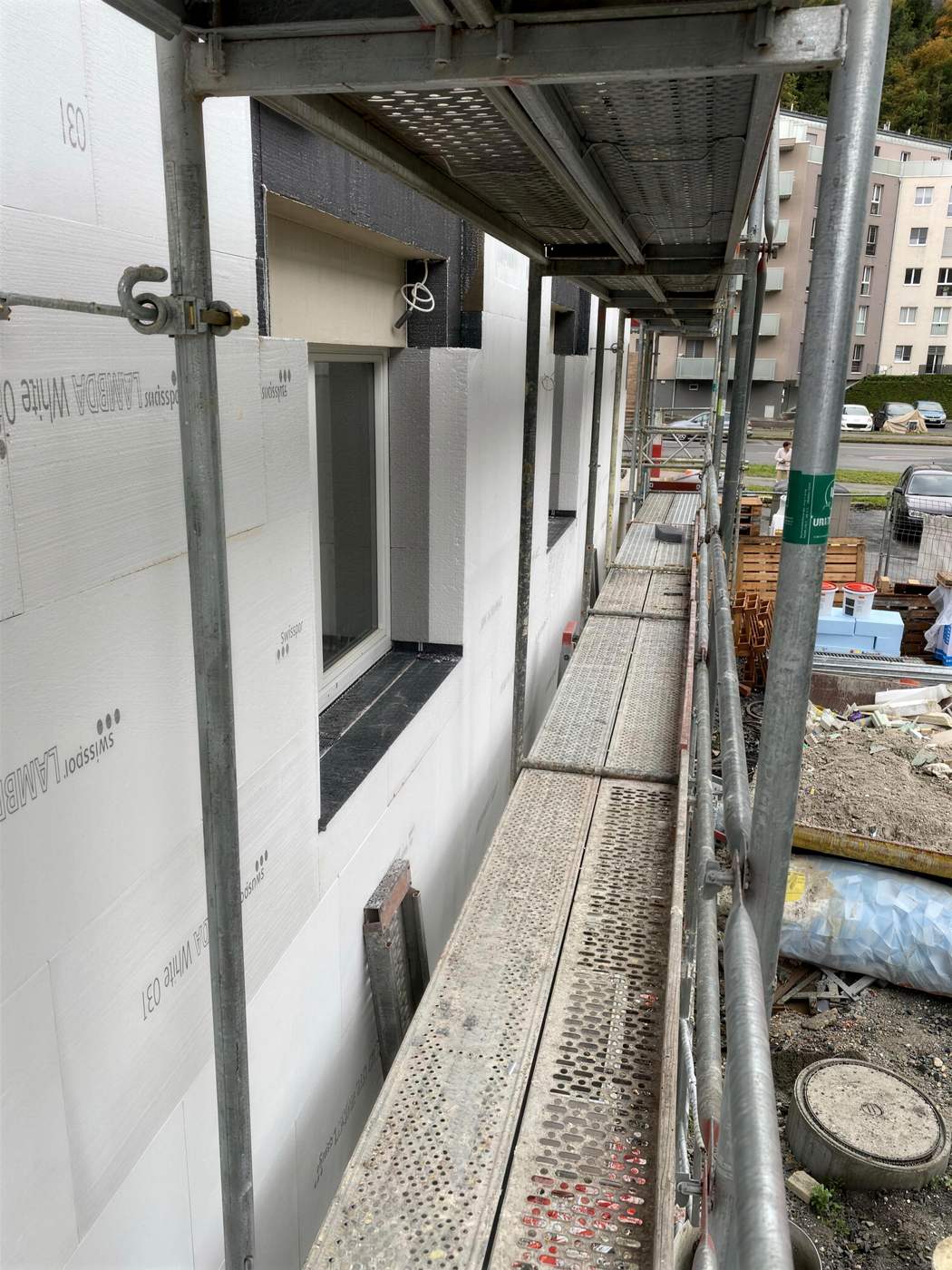 Façade d’immeuble sous échafaudage, panneaux isolants en cours de pose