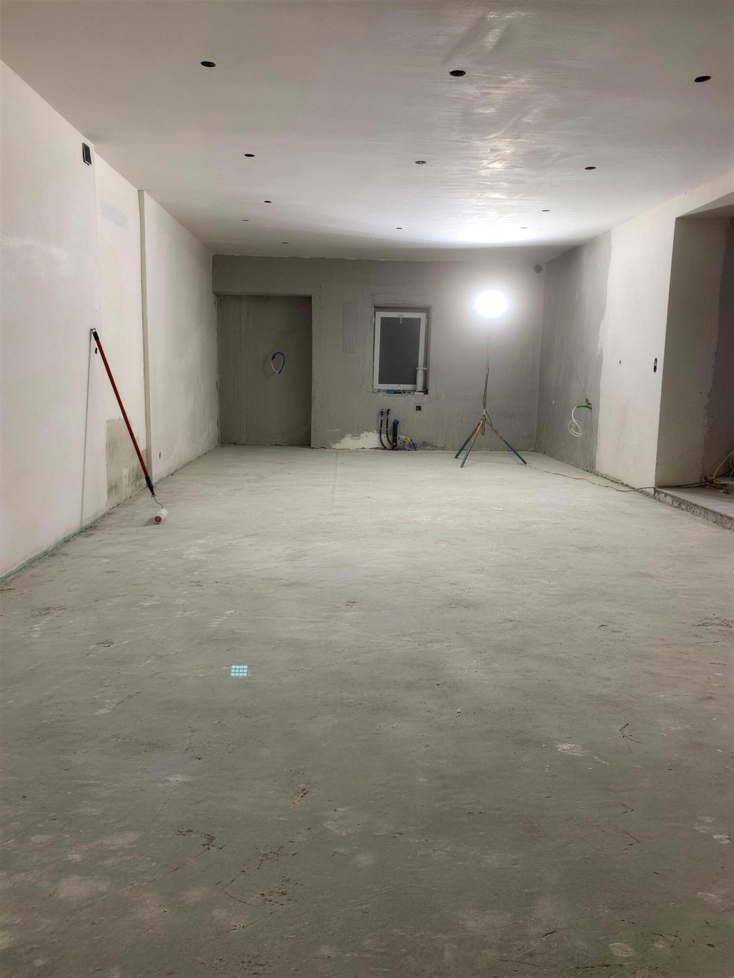 Intérieur brut, sol et murs en béton, lampe de chantier